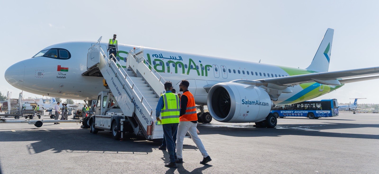 A SalamAir aircraft on the apron at Mogadishu during the launch, with ground crew walking to the boarding stairs