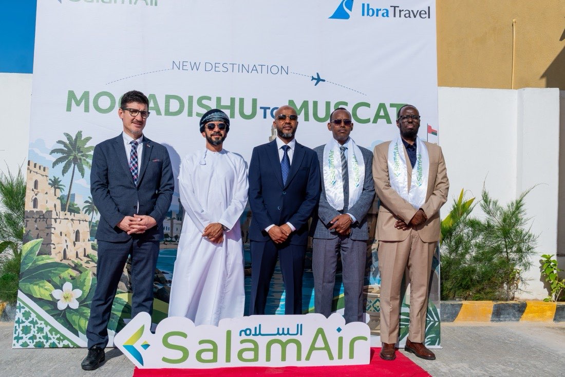 Five guests in front of the Mogadishu to Muscat launch backdrop, which carries the SalamAir and Ibra Travel logos