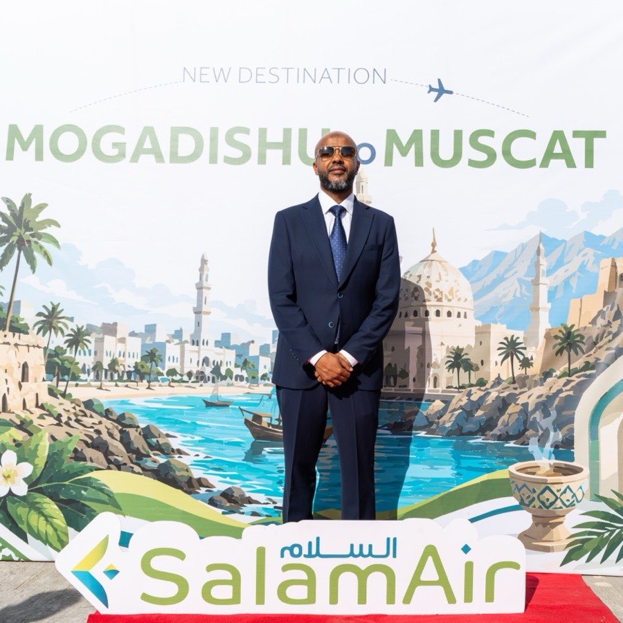 Abdisalam A. Ibrahim, Managing Director of Ibra Travel, in front of the Mogadishu to Muscat launch backdrop